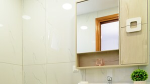 Een badkamer met toilet, wastafel en kast.