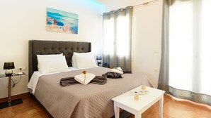 Een hotelkamer met een groot bed, nachtkastje, schilderij aan de muur en een raam met gordijnen.