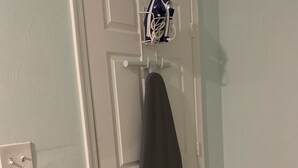 A white door with a towel hanging on a rack, a power outlet, and a light switch.