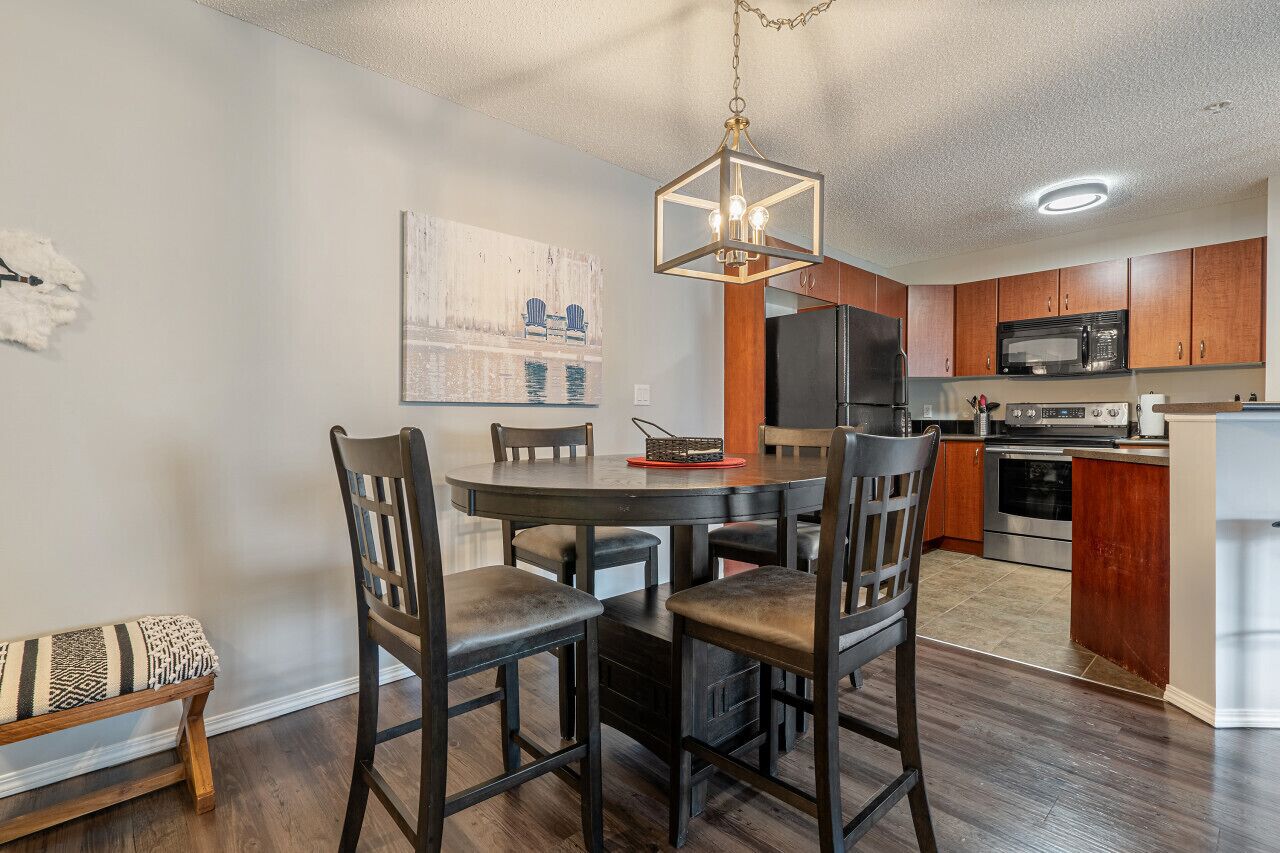 A modern kitchen with wooden cabinets, a stainless steel refrigerator, and a built-in microwave.