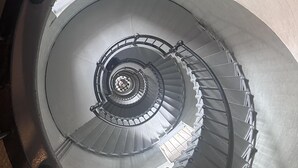 A spiral staircase with metal railings and a circular landing area.