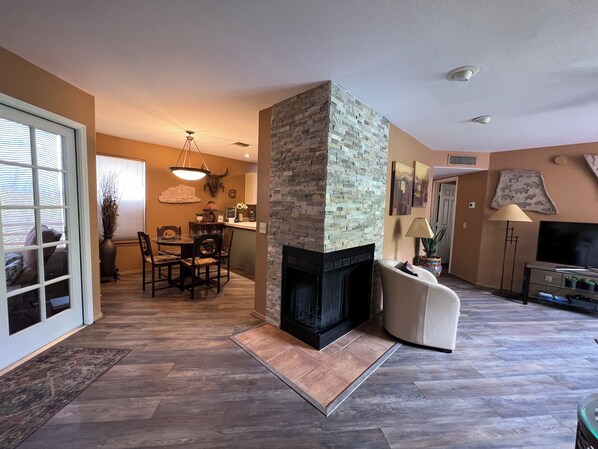 A living room with a fireplace, a dining area, and a TV.