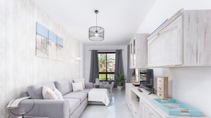 A modern living room with a sofa, a coffee table, a TV, and a cabinet. - Home2Book Jable Beach Apartment (Morro Jable)