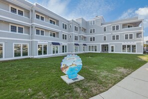 A multi-story building with a modern architectural design, featuring a central courtyard and a large decorative sign. - Thomas Sea Suites (Plymouth)