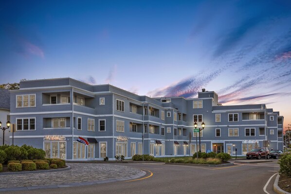 A multi-story hotel with a modern architectural design, featuring a prominent entrance with a sign, and a well-maintained landscaped area in front. - Thomas Sea Suites (Plymouth)