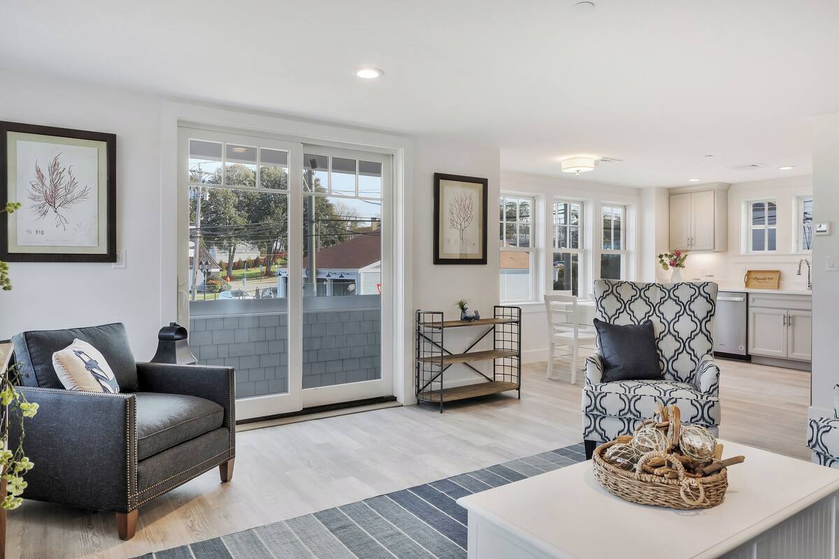 A modern living room with a sofa, armchair, and a coffee table with decorative items.