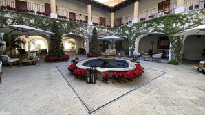 A courtyard with a central fountain, seating areas, and Christmas decorations. - Beach Front Pool Fully Kitchen Breathtaking Sea Views Close to Everything (San Jose Del Cabo)