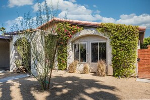 A house with a stone facade, a window with a white frame, and a red-tiled roof. - Casa Mesquite - Lovely Bungalow in S Palm Springs (Palm Springs)