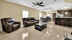 A spacious living room with a brown leather sofa, a recliner, and a coffee table. - Relax & Enjoy In Our Spacious Townhome Getaway! (McAllen)