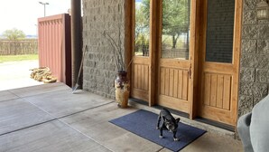 Un perro sobre una estera frente a un edificio con paredes de piedra y puertas de madera.