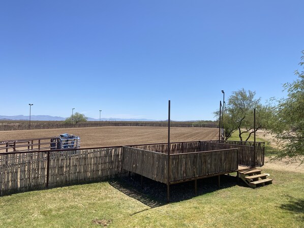 Un espace clos, doté d’une terrasse en bois et où se trouve un véhicule bleu.
