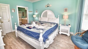 A bedroom with a bed, a nightstand, a chair, a door, and a ceiling fan. - Lake & Pool View in the Heart of Myrtle Beach, SC-Magnolia Pointe-Myrtlewood (Myrtle Beach)