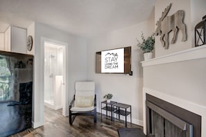 Relax in a cozy space with a comfortable seating area, fireplace, and wall-mounted TV.
