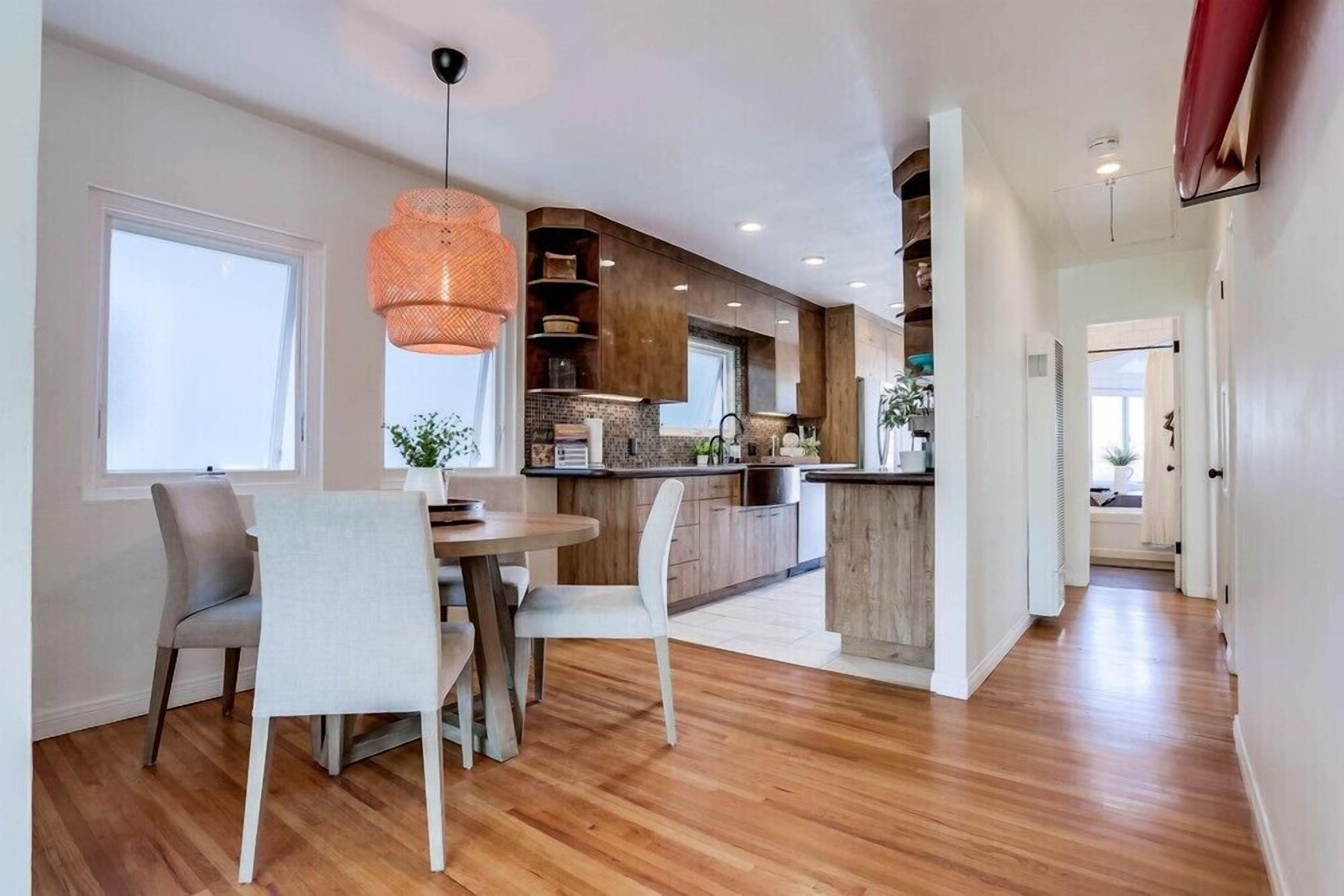 Una cocina moderna con armarios de madera, una isla central e iluminación colgante.