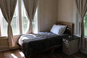 A bedroom with a bed, nightstand, and curtains. -  Charming house near Maramec Spring Park, Steelville/St. James (Steelville)