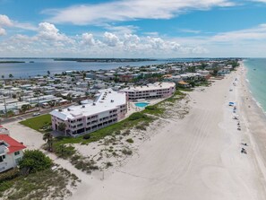 Un hôtel situé sur la côte, composé de plusieurs bâtiments, avec une plage et une vue dégagée sur l’océan.