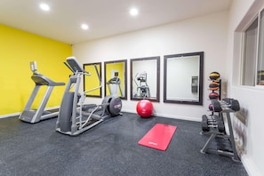 A gym with treadmills, elliptical machines, a red mat, a red exercise ball, and a set of dumbbells. - Days Inn By Wyndham Kimball (Kimball)