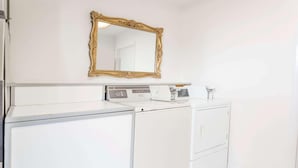 A laundry area with a white washing machine, a dryer, and a large mirror on the wall. - Days Inn By Wyndham Kimball (Kimball)