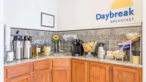 A kitchen with a Daybreak Breakfast sign, stainless steel appliances, and a tiled backsplash. - Days Inn By Wyndham Kimball (Kimball)