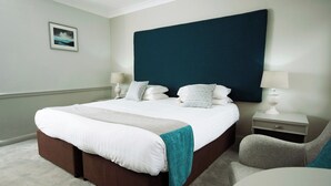 A hotel room with a large bed, bedside tables, a chair, and a framed picture on the wall. - Crown Hotel Wetheral (Carlisle)