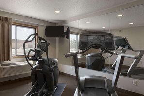 A gym with an elliptical machine, a treadmill, and a mirrored wall. - Super 8 by Wyndham Sioux Falls/41st Street (Sioux Falls)