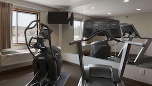A gym with an elliptical machine, a treadmill, and a mirrored wall. - Super 8 by Wyndham Sioux Falls/41st Street (Sioux Falls)