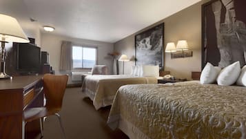A hotel room with two beds, a desk, a chair, a television, and a large abstract painting on the wall.