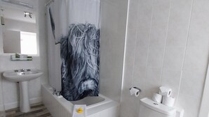Ein Badezimmer mit Badewanne, Toilette, Waschbecken und Duschvorhang.
