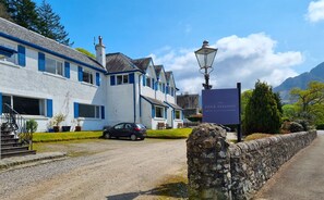 A traditional white building with blue shutters, a stone wall, and a sign for The Four Seasons Hotel & Little Larder. - The Four Seasons Hotel (Crieff)