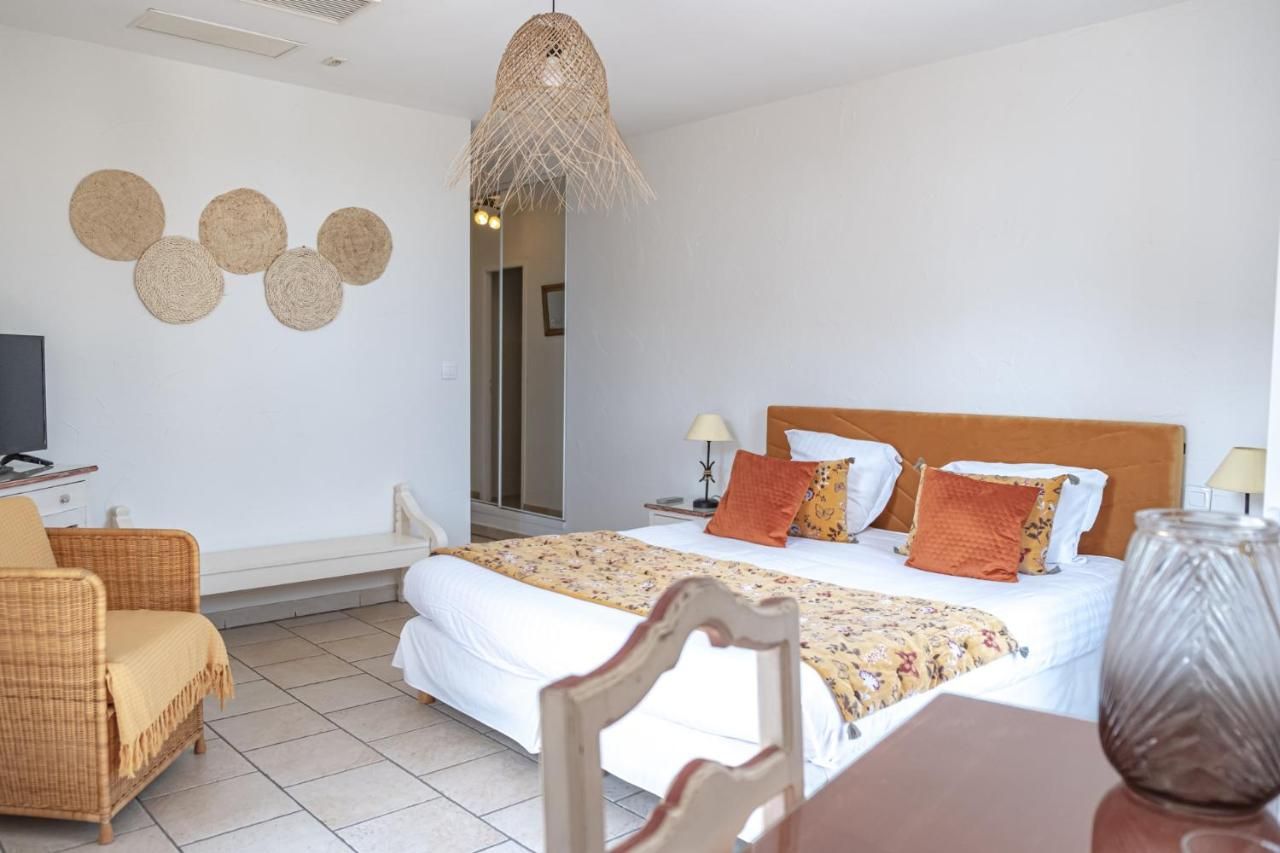 Een slaapkamer met een bed, een stoel, een tafel, een lamp en een hangende lamp.
