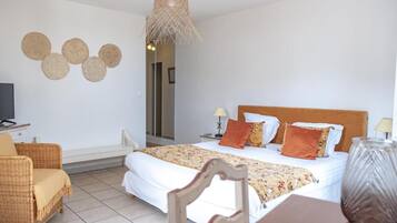 Een slaapkamer met een bed, een stoel, een tafel, een lamp en een hangende lamp.
