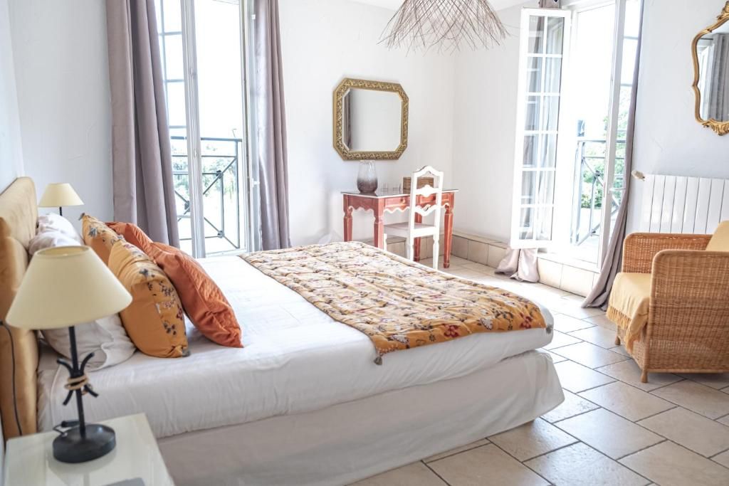 Une chambre à coucher avec un lit, un bureau, une chaise, un miroir et un balcon.