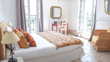 Une chambre à coucher avec un lit, un bureau, une chaise, un miroir et un balcon.