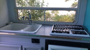 Une cuisine équipée d’un évier, d’une cuisinière et d’un four à micro-ondes.