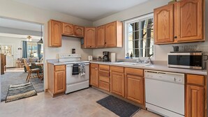 A kitchen with wooden cabinets, a white stove, a dishwasher, and a microwave. - Walking Distance to Town__Discount Ski Passes __TRAVELERS WELCOME (La Grande)