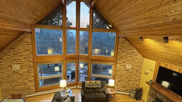 Un loft espacioso con techo alto, ventanas grandes, chimenea y una zona de estar acogedora.