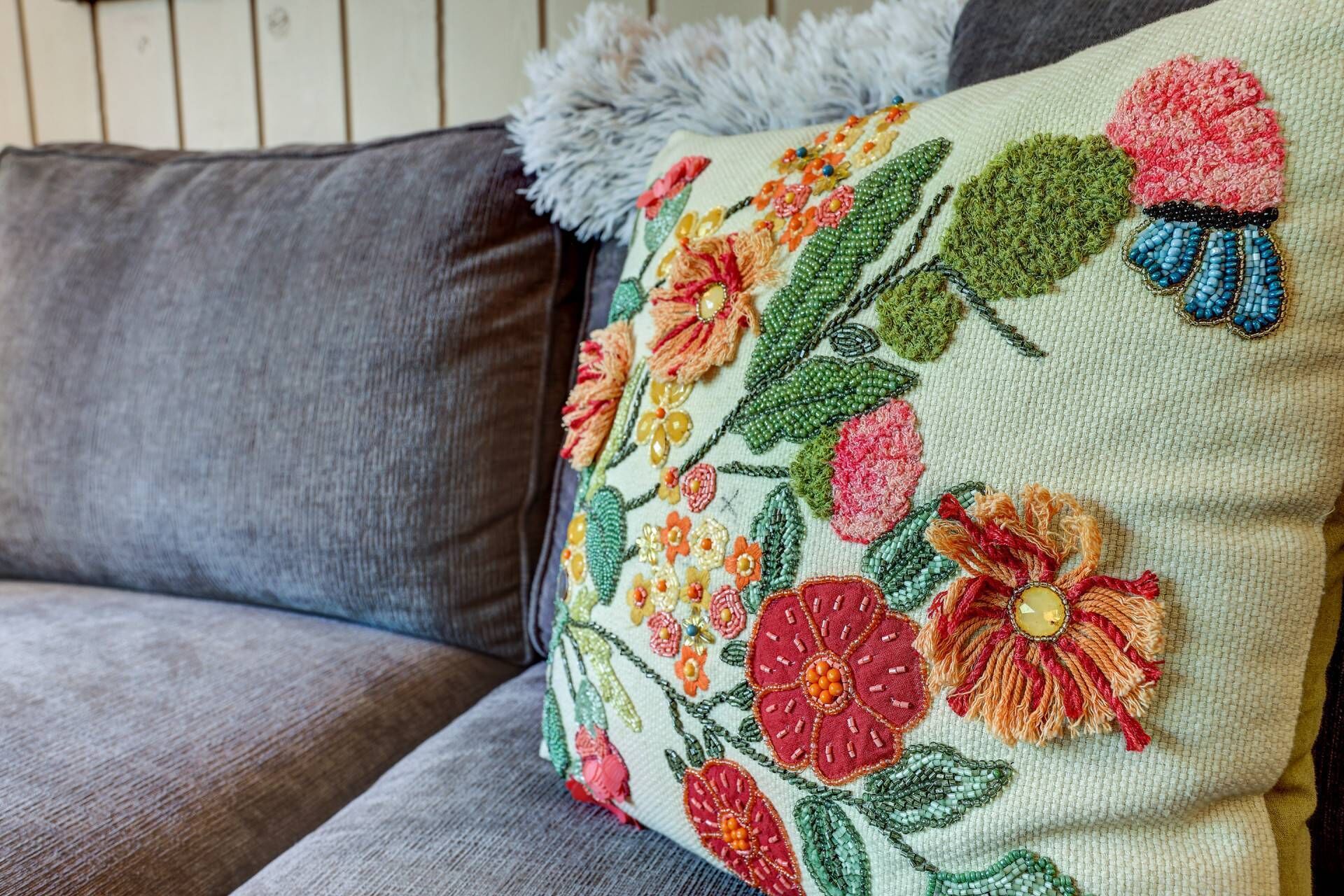 Un coussin orné d’un motif floral brodé.