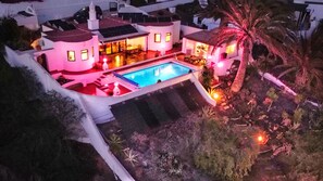Una casa espaiosa amb piscina, diverses habitacions i una zona exterior ben il·luminada.