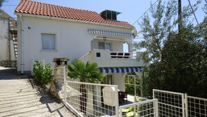 Ein zweistöckiges Gebäude mit rotem Ziegeldach, einem Balkon und einem verschlossenen Eingang.