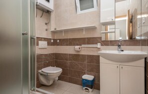 Une salle de bain moderne équipée de toilettes, d’un lavabo et d’une douche.