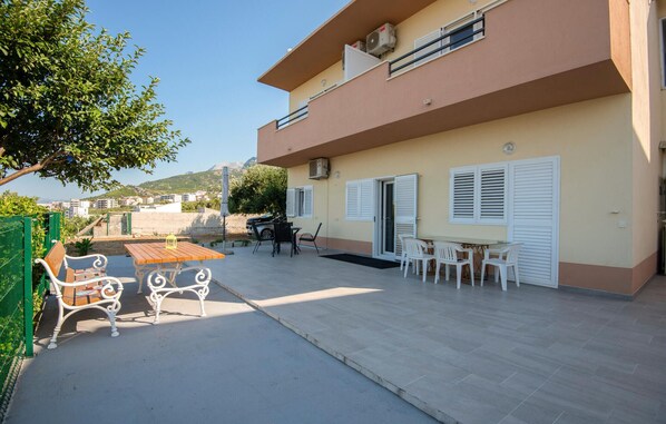Une terrasse extérieure avec une table et des chaises, un banc et une vue sur une colline.