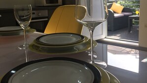 A dining area with a table set for two, including plates, cutlery, and wine glasses. - Sunflower-beautiful Modern Apt. w. Terrace&garden (Kastela)