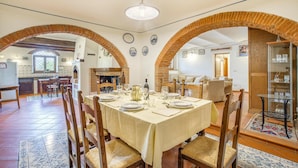 A dining area with a table set for four, surrounded by wooden chairs with woven seats.
