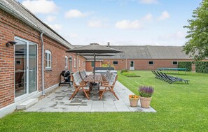 Une terrasse avec une table et des chaises, un barbecue et un jacuzzi.