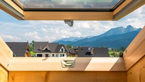 Interior de madera con tragaluces que dan vista a un paisaje montañoso.