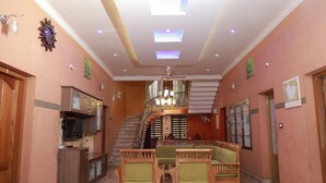 Eine großzügige Lobby mit Treppe, Holzmöbeln und einer Chandelier.