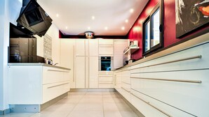 A modern kitchen with white cabinets, a built-in oven, and a window with a view. - Amazing home in St Victor la Coste (St Victor la Coste)