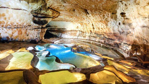 A cave interior with stalactites and stalagmites, a reflective water feature, and a metal railing. - Amazing home in St Victor la Coste (St Victor la Coste)