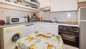 Cocina compacta con lavadora, microondas, estufa y horno.