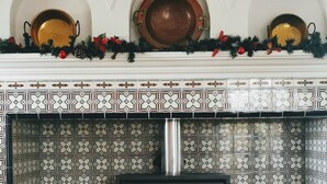 Un camino con mensola decorata, un fuoco di legna e una ghirlanda ornamentale.